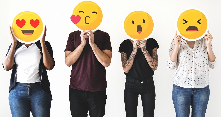 Diverse people holding emoticon